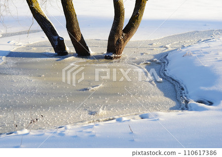 Winter specific. Frozen river. Winter wonderland. Snow-blanketed countryside, the calm and serenity of a winter day in the heart of the rural landscape. 110617386