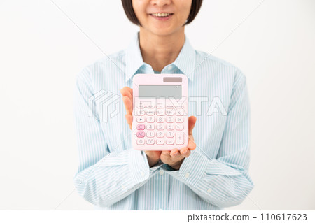 A middle-aged woman holding a calculator and smiling 110617623