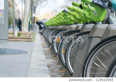 Bicycle for rent, number of wheels is on parking. 110618093