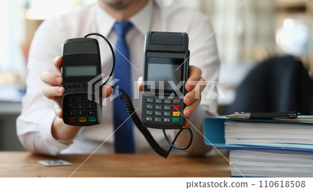 Businessman holding different pos terminals in his hands closeup 110618508