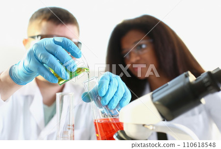 Two researchers are conducting experiments with chemical liquid in laboratory Two researchers are conducting experiments with chemical liquid in laboratory 110618548