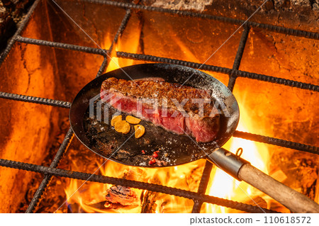 Grill a steak over an outdoor 110618572