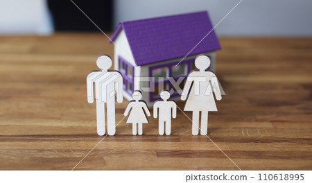 Wooden figurines of parents and children on background of house. 110618995