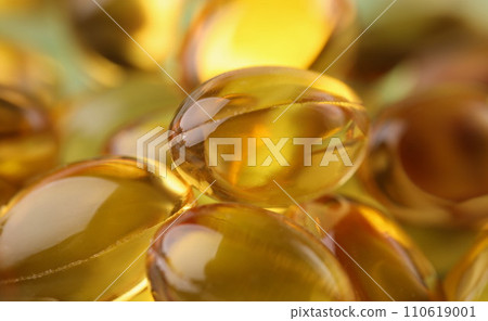 Golden transparent capsules in organic packaging closeup Golden transparent capsules in organic packaging closeup 110619001