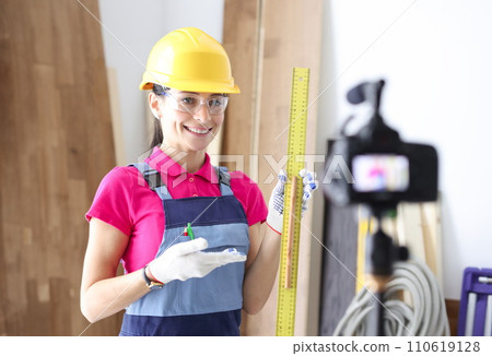 Woman builder demonstrates ruler on video camera Woman builder demonstrates ruler on video camera 110619128