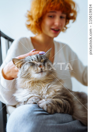portrait red-haired attractive young woman with fluffy domestic cat 110619934