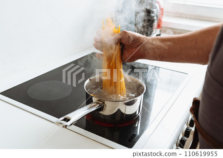 man cooking spaghetti in kitchen 110619955