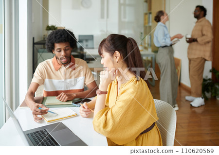 UI designer and front end developer discussing website interface 110620569