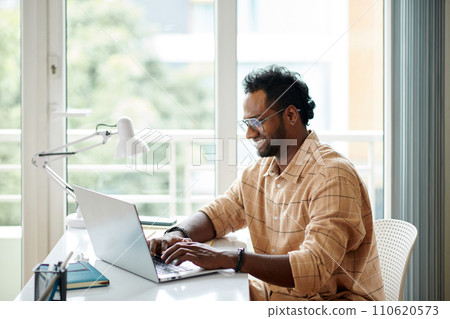 Smiling developer answering e-mails from happy mobile application users 110620573