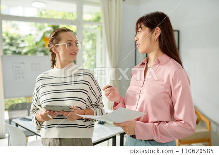 UX developer and graphic designer discussing mobile application update 110620585