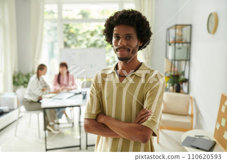 Smiling confident community manager standing in light cozy small company office Smiling confident community manager standing in light cozy small company office 110620593