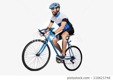Bearded caucasian cyclist wearing sports equipment, riding bike. Side view of male cyclist making effort to ride fast, isolated on white studio background. Concept of sport lifestyle, action, motion. Bearded caucasian cyclist wearing sports equipment, riding bike. Side view of male cyclist making effort to ride fast, isolated on white studio background. Concept of sport lifestyle, action, motion. 110621748