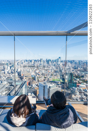 Sitting on a sofa set up with “Tokyo Metropolitan” and looking at Tokyo at Shibuya Sky Sitting on a sofa set up with “Tokyo Metropolitan” and looking at Tokyo at Shibuya Sky 110622163