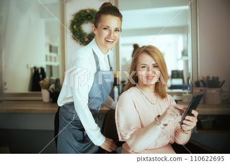 40 years old woman hairdresser in modern hair studio 40 years old woman hairdresser in modern hair studio 110622695