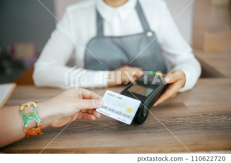 Hair salon employee accepting credit card payments via terminal 110622720