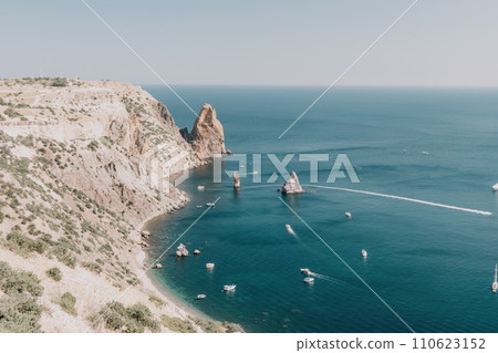 Aerial view from above on calm azure sea and volcanic rocky shores. Small waves on water surface in motion blur. Nature summer ocean sea beach background. Nobody. Holiday, vacation and travel concept 110623152