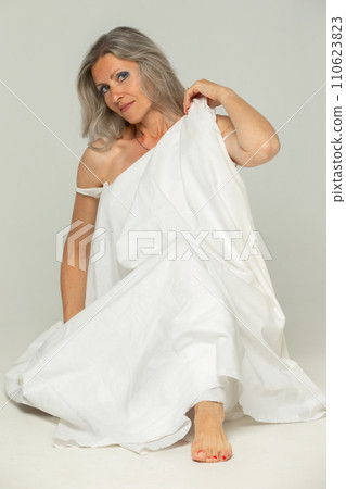 Beautiful grey-haired 50s woman looking at camera isolated on white.  110623823