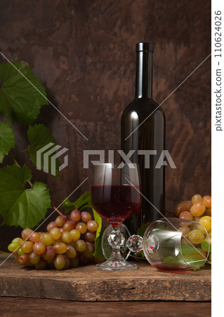 Still life with glasses of red wine and grapes on vintage wooden background.. Still life with glasses of red wine and grapes on vintage wooden background.. 110624026