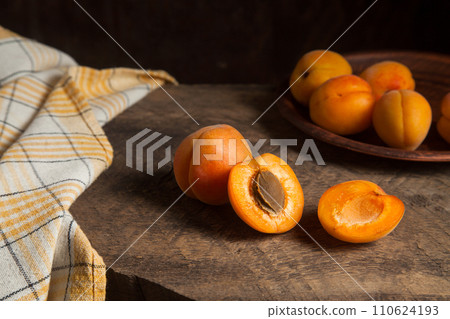 Apricot fruit whole and half on wooden background.. 110624193