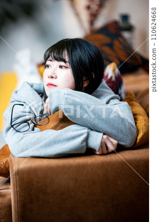 A woman lying on the sofa and relaxing A woman lying on the sofa and relaxing 110624668
