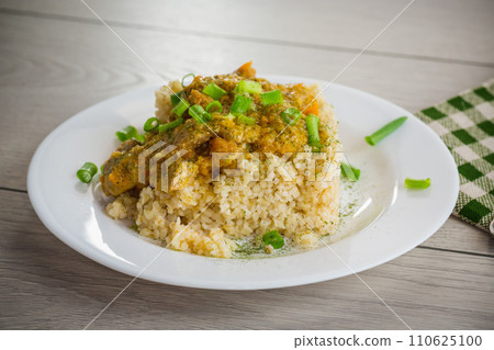 cooked bulgur with meat sauce and vegetables in a plate 110625100
