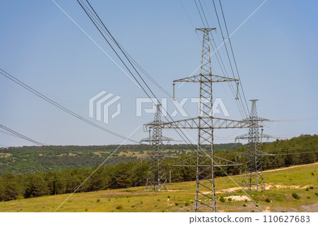 High voltage towers Electric pole. Power line support with wires for electricity transmission. High voltage grid tower with wire cable at distribution station. Energy industry, energy saving High voltage towers Electric pole. Power line support with wires for electricity transmission. High voltage grid tower with wire cable at distribution station. Energy industry, energy saving 110627683