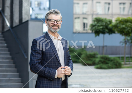 Mature male executive looking content outdoors. He portrays success and professionalism in his business attire. 110627722