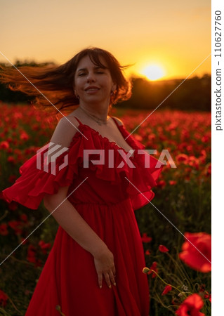 Woman poppy field red dress sunset. Happy woman in a long red dress in a beautiful large poppy field. Blond stands with her back posing on a large field of red poppies 110627760