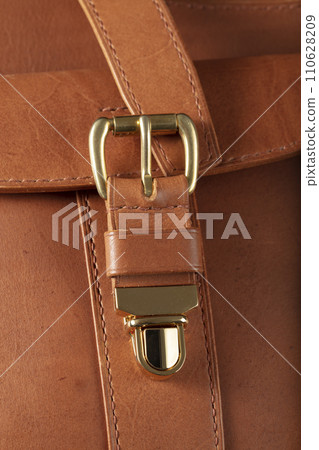 Part of a brown genuine leather bag with a metal latch. Part of a brown genuine leather bag with a metal latch. 110628209
