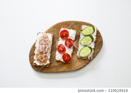Ingredients for sandwich with boiled egg, cherry tomatoes, canned tuna, garlic and spices over grey white grunge background. Top view Ingredients for sandwich with boiled egg, cherry tomatoes, canned tuna, garlic and spices over grey white grunge background. Top view 110628428