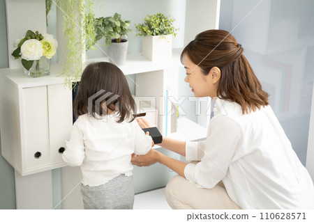 A girl cleaning up with her mother 110628571
