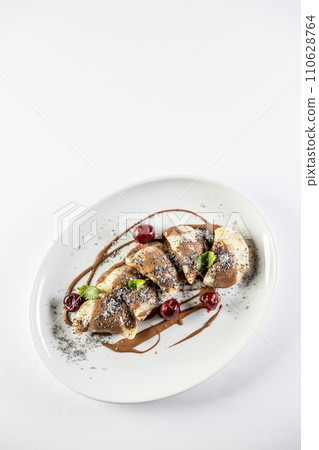 Eastern European traditional food dumplings - pierogi, varenyky, pirohy filled with strawberries and topped with chocolate. Isolated on white 110628764