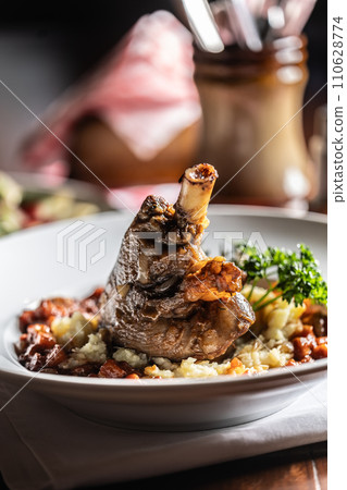 Confit lamb calf on mashed potatoes and baking sauce. Roasted leg of mutton with potatoes on a plate in a restaurant 110628774