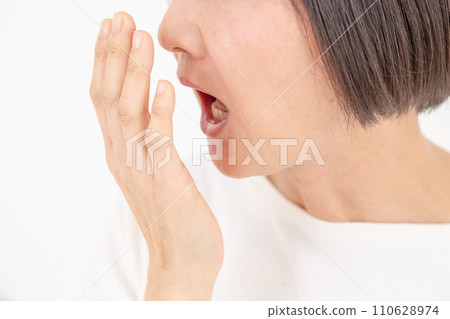 Middle-aged woman checking bad breath Middle-aged woman checking bad breath 110628974