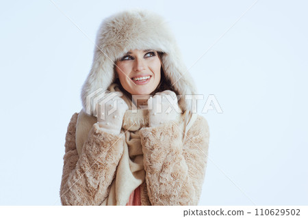 smiling stylish woman in winter coat and fur hat on white smiling stylish woman in winter coat and fur hat on white 110629502