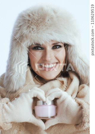 smiling stylish woman in winter coat and fur hat on white smiling stylish woman in winter coat and fur hat on white 110629519