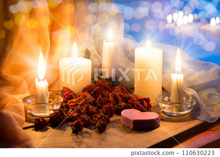 Candles and dried rosebuds on the table 110630223