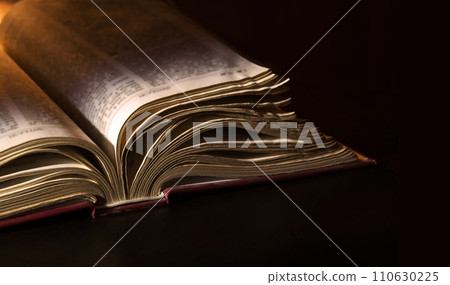 Dark table with open bible Dark table with open bible 110630225