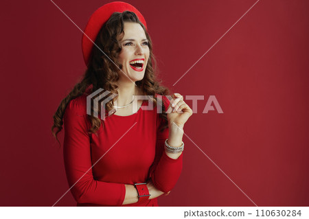 smiling elegant woman in red dress and beret on red background smiling elegant woman in red dress and beret on red background 110630284