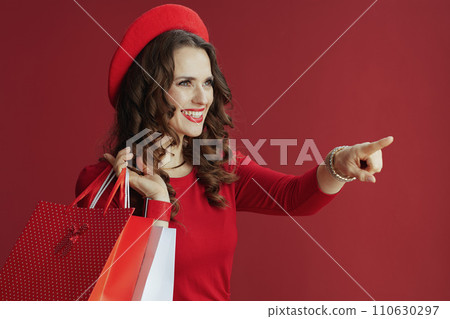 happy woman pointing at something isolated on red background happy woman pointing at something isolated on red background 110630297