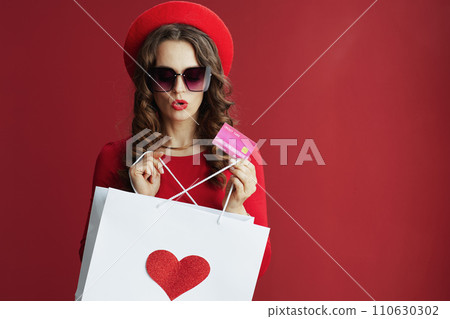 surprised woman on background with shopping bag and heart 110630302
