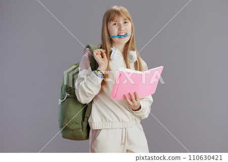 Portrait of smiling trendy teenager girl in beige tracksuit 110630421