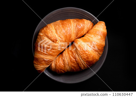 Golden croissants on a black background, top view. Fresh butter croissants 110630447