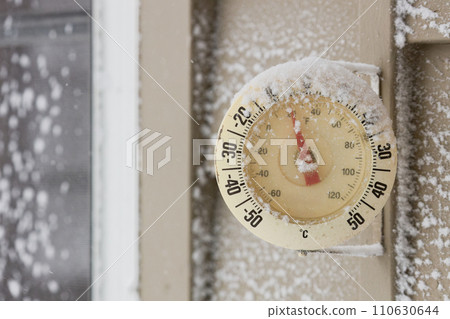 Snow Capped Thermometer Mounted on Wooden Siding of House Showing Freezing Temperatures 110630644