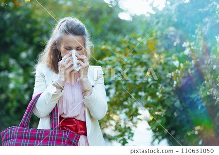 stylish woman in dress and jacket in city has allergy attack 110631050