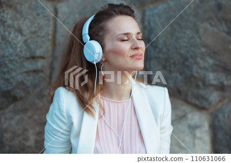 elegant woman in pink dress and white jacket in city 110631066
