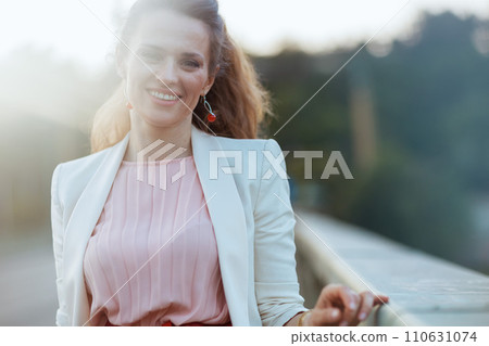 Portrait of smiling woman in dress and jacket in city Portrait of smiling woman in dress and jacket in city 110631074