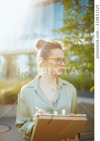 pensive modern woman employee in green blouse and eyeglasses pensive modern woman employee in green blouse and eyeglasses 110631525