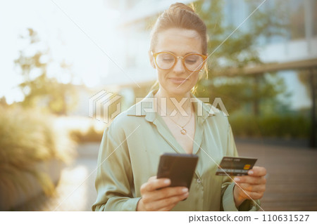 pensive modern woman worker in green blouse and eyeglasses pensive modern woman worker in green blouse and eyeglasses 110631527