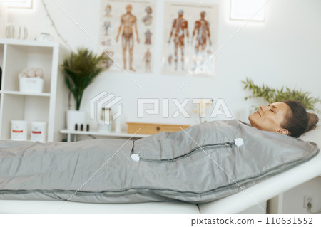 woman doing whiskey swaddling procedure in thermal blanket 110631552